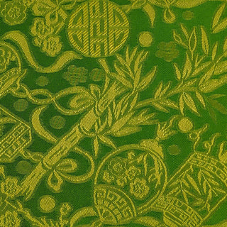 Close up of jacquard silk fabric with intricate patterns of bamboo, lanterns and symbols in two shades of green.