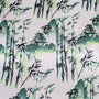 Polyester silk fabric features a green print of pagodas and temples above misty hilltops with large bamboo trees. 