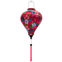 Balloon shaped Vietnamese silk lantern with hibiscus flowers set against a bright hot pink background.