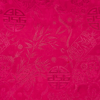 Close up of jacquard silk fabric with intricate patterns of bamboo, lanterns and symbols in hot pink colour.