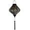 Glowing Lozenge shaped Lantern with colourful cross stitched hummingbirds in flight amongst blue bell flowers and bright green leaves on black.