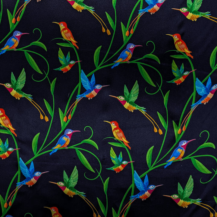 Polyester silk fabric with a prink of blue and orange hummingbirds sitting and flying amongst green plants on dark blue background used to create the Hoi An Lantern.