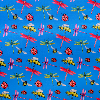 A close up of polyester silk fabric with a print of dragonflies, lady bugs and bees on bright blue background.