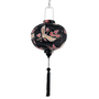 Round lantern with floral and bird patterns on a black background