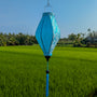 Blue and Silver Jacquard silk lantern hanging against a green field and blue sky