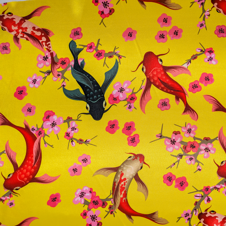 Polyester silk fabric with a design of koi fish swimming among cherry blossoms on a bold yellow background.