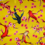 Polyester silk fabric with a design of koi fish swimming among cherry blossoms on a bold yellow background.