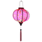 Glowing Round shaped Vietnamese lantern with pink tassels featuring a design of cranes, lanterns, firecrackers, and blooms of pink and yellow on a brilliant pink background. 