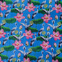 A striking fabric design featuring a vibrant blue background adorned with grey-crowned cranes standing among large green lotus leaves. The pattern includes blooming pink lotus flowers, unopened buds, and seed pods. The cranes, with their distinctive golden crests and black-and-white plumage.