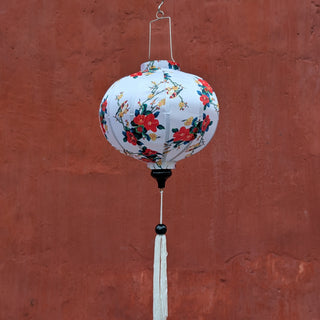 Round shape lantern with lovebirds on white hanging in front of the Japanese Bridge wall in Hoi An, Old Town.
