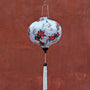 Round shape lantern with lovebirds on white hanging in front of the Japanese Bridge wall in Hoi An, Old Town.