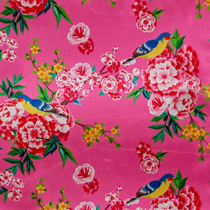Polyester silk fabric with blue birds surrounded by pink and yellow flowers in bloom on gorgeous bright pink background used to create Hoi An Lanterns.