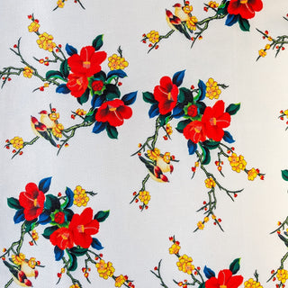 Polyester silk fabric with a print of love birds sitting on branches with orange and yellow flowers on a white background. This fabric is used to hand make our Vietnamese Lanterns in Hoi An.