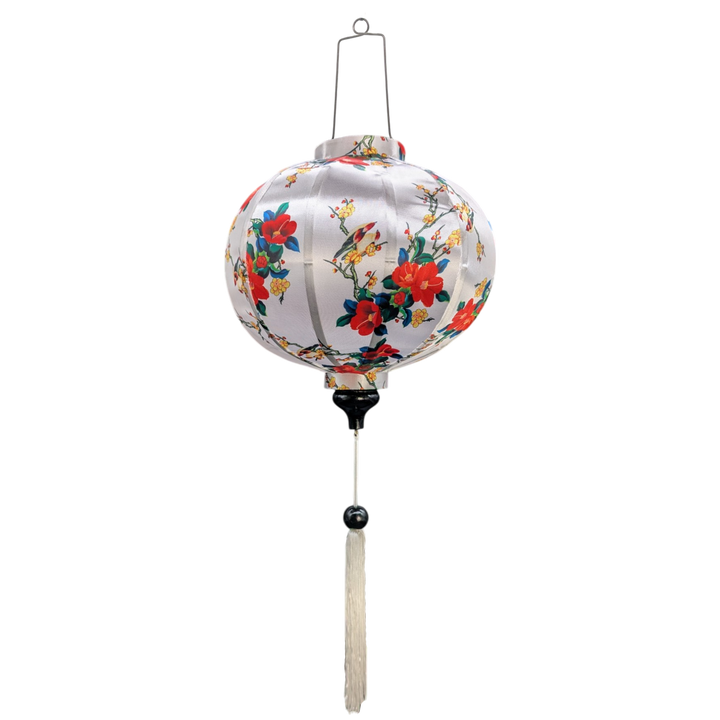A beautifully handcrafted Hoi An silk lantern with a round shape and a white fabric base. The lantern is adorned with a delicate floral pattern featuring vibrant red and yellow blossoms intertwined with green branches. Perfect for home decor, festive occasions, or as a unique gift.