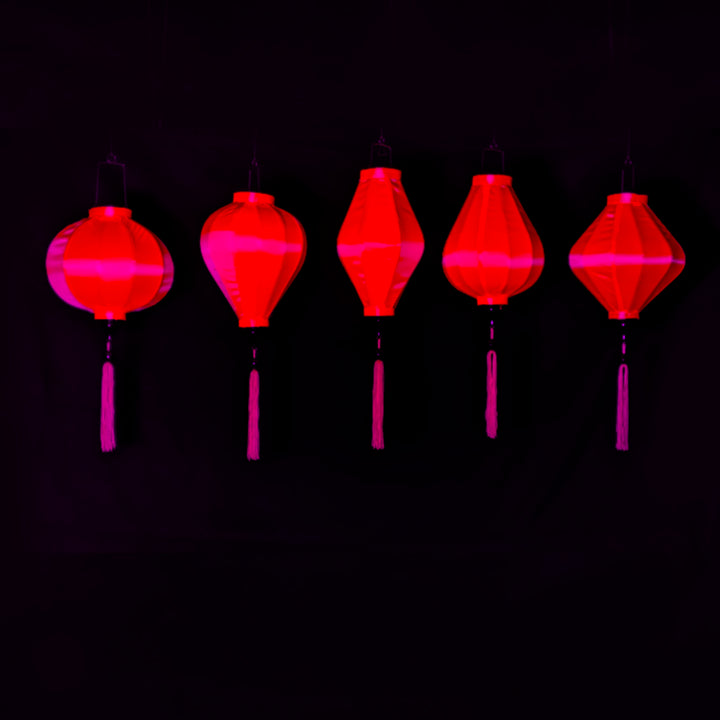 A row of hot pink lanterns glowing under UV light.