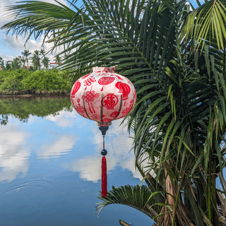 Round Hoi An Lantern hanging outside in front of the Thu Bon River.