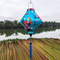 Lozenge shaped lantern outdoors with blue tassel and large orange birds on blue super silk fabric.
