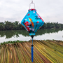 Lozenge shaped lantern outdoors with blue tassel and large orange birds on blue super silk fabric.
