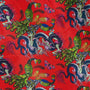 Close up of polyester silk fabric adorned with intricate prints of dragons, peacocks, and butterflies against a striking red background.