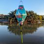 Tube shaped Vietnamese Lantern hanging in Old Town with a print of pelicans, proteas, orchids, and hibiscus against a serene light mint green.