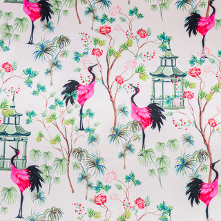 A vibrant polyester silk fabric print featuring elegant pink and black cranes among lush green foliage and delicate blooming flowers. The scene is accented with traditional Asian-style pagodas, creating a serene yet bold aesthetic with intricate details and rich colours.