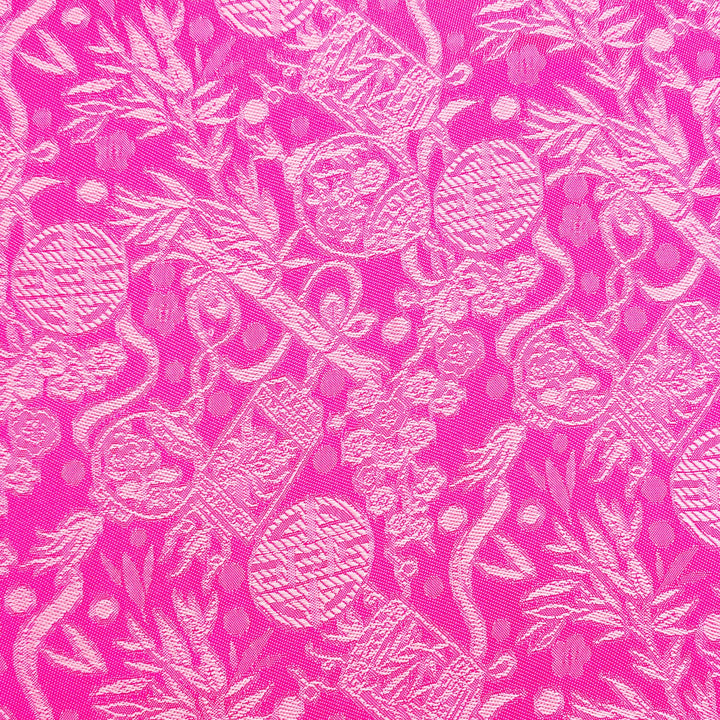 Close up of jacquard silk fabric with intricate patterns of bamboo, lanterns and symbols in silver sheen against pink.