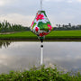 Teardrop shape Vietnamese silk lantern with white tassel and fabric with a print of bright pink lotus flowers against a white background.