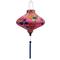 UFO shaped Vietnamese lantern with blue tassel, cranes, pink and yellow chrysanthemum flowers on a pink background. 