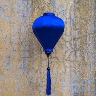 Blue balloon shaped lantern hanging in front of an old wall in Old Town, highlighting the blue in the wall.