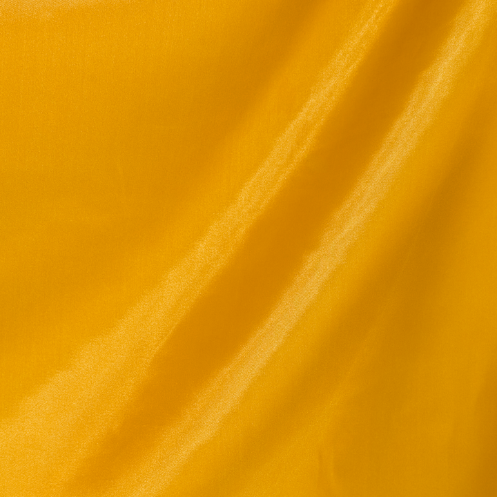 Close-up of our polyester silk plain Gold fabric used to create Vietnamese silk lanterns.