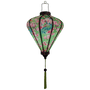 Glowing silk lantern with red-headed woodpecker birds sitting in cherry blossom trees on a bright green background.