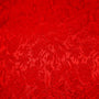 Close up of jacquard silk fabric with intricate patterns of flowers, bamboo, lanterns and symbols in red colour.