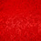 Close up of jacquard silk fabric with intricate patterns of flowers, bamboo, lanterns and symbols in red colour.