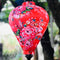 Close up of a balloon shape lantern featuring a print of pink roses against striking red silk.
