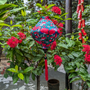 Lantern featuring a print of bright red flowers on deep green background made from silk and bamboo.