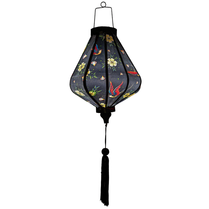 Glowing Teardrop shaped Vietnamese Hoi An lantern with flying swallows set against a bold black backdrop adorned with diamonds and yellow daisy flowers. 