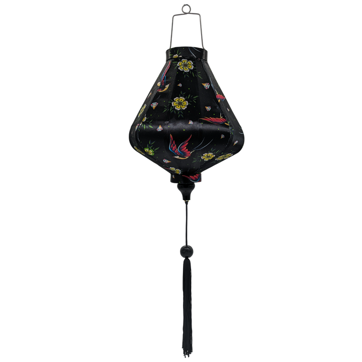 Teardrop shaped Vietnamese Hoi An lantern with a print of flying swallows with striking red and blue wings set against a bold black backdrop adorned with diamonds and yellow daisy flowers. 