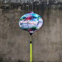 Round Vitenamese Lantern with green tassel hanging outside against a grey wall.
