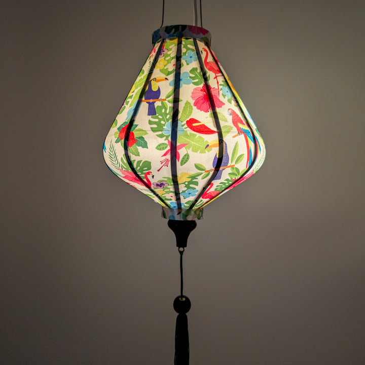 Glowing Teardrop shaped lantern wuth tropical birds and plants hanging 
