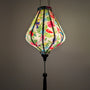 Glowing Teardrop shaped lantern wuth tropical birds and plants hanging 