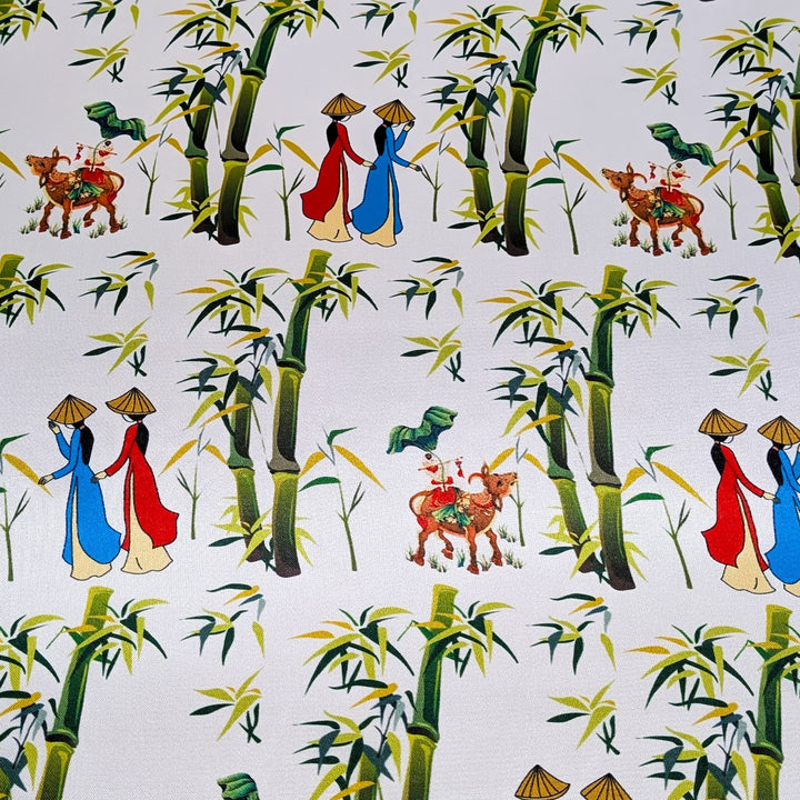 Polyester silk fabric captures the essence of traditional Vietnam with a charming countryside scene featuring women in áo dài, bamboo groves, and little boys playing an instrument while sitting on water buffalos. 