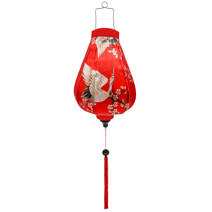 Garlic shaped Vietnamese lantern with red-headed cranes flying and swooping around small pink and white cherry blossoms on a bold red background.
