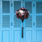 Round shaped Vietnamese Hoi An lantern featuring red-headed white cranes amongst pink cherry blossoms against a black background hanging in front of blue shutters. Perfect for home decor.