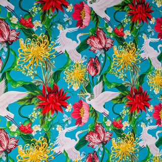 Vibrant fabric with cranes & floral print featuring graceful white cranes in flight, surrounded by a lush tapestry of red dahlias, golden chrysanthemums, and delicate blossoms. 