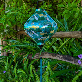 Lozenge shaped lantern hanging among green foliage