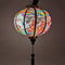 Up close of a Vietnamese round lantern glowing with a lightbulb placed and lit from inside.