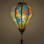 Glowing Balloon shape lantern featuring an abstract floral print with intricate swirls and bold hues of blue, red, yellow, and orange.