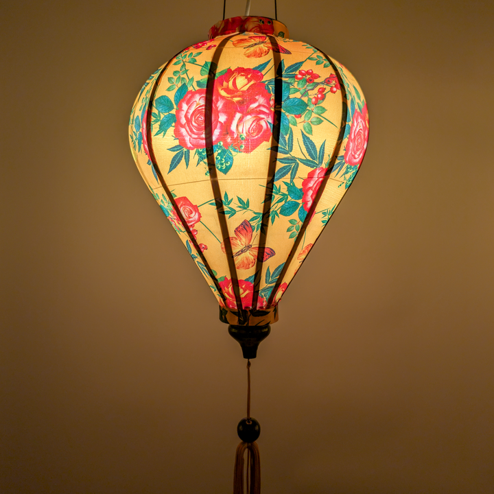 Glowing balloon silk lantern with roses and butterflies design on a yellow background