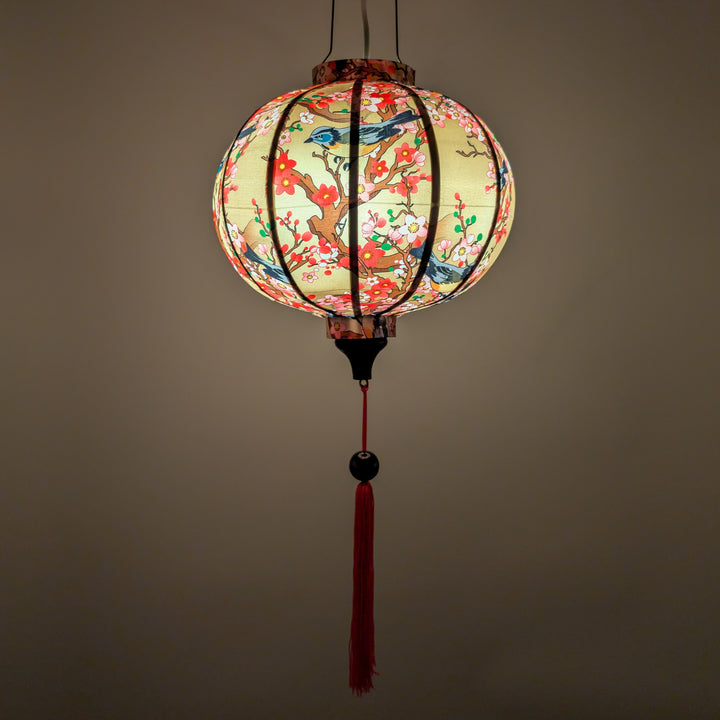 Round glowing silk lantern with floral and bird pattern on a cream background