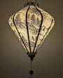 Lantern with tree pattern on a white background creating a warm soft glow.
